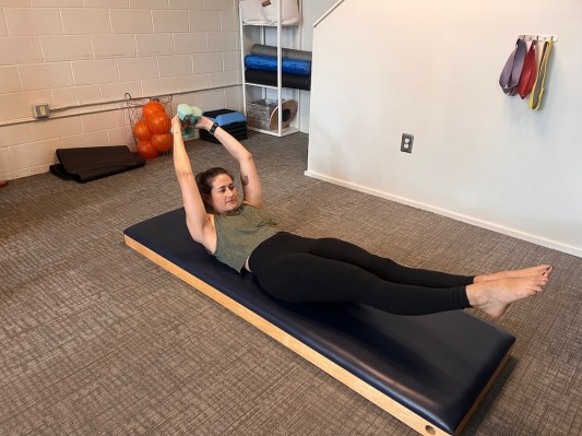 Pilates instructor demonstrates double leg stretch