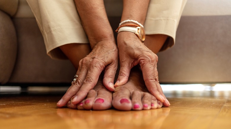 A seated woman touches her toes