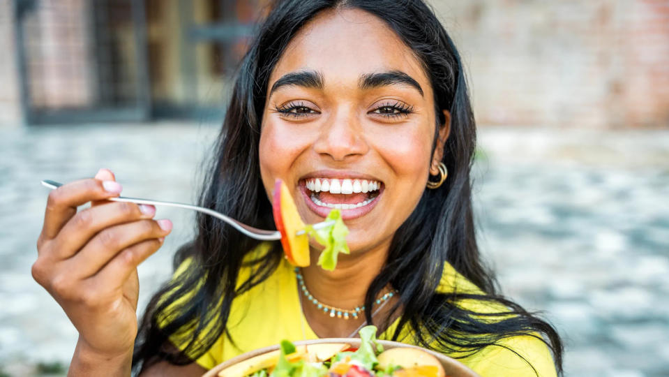 Happy woman eating salad