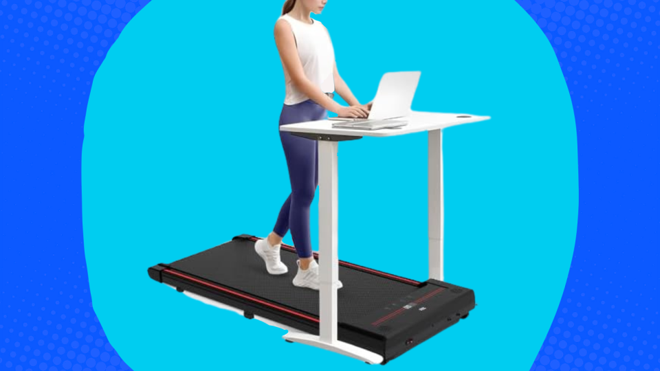 Someone walks on the treadmill under their desk while working on a laptop