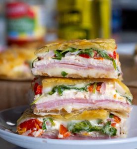 Deli Squares! Layers of melty cheese, savory deli meats, roasted red peppers, and fresh veggies are all wrapped in buttery puff pastry for a dish that’s sure to wow.